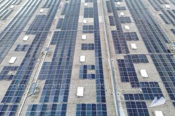 Großflächige Photovoltaikanlage (Solarmodule) auf dem Flachdach eines großen Logistikgebäudes