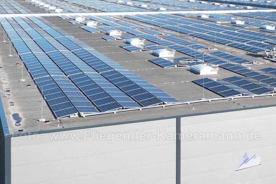 Großflächige PV-Anlage auf gewerblichen Flachdach mit Solarmodulen, Aufständerungen und Dachentlüftungen