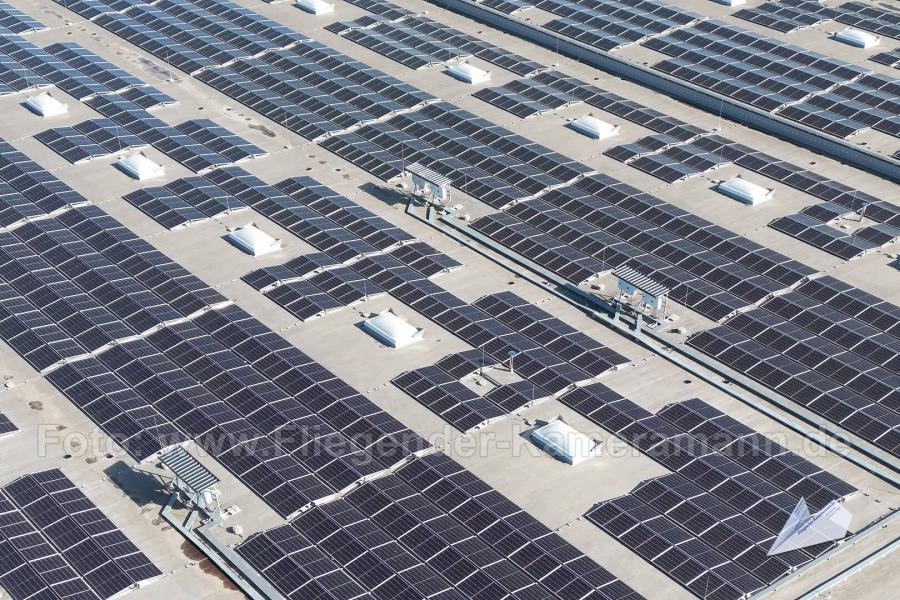 Drohnenaufnahme von großflächige Photovoltaikanlage auf dem Flachdach eines Logistikgebäudes.