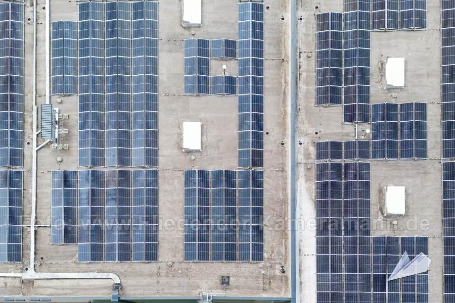 Luftaufnahme von Photovoltaik-Modulen auf einem Flachdach zur visuellen Überprüfung der montierten Solarmodule.