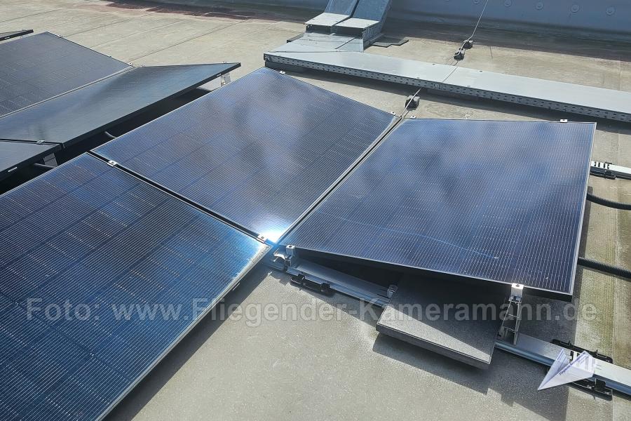 Aufgeständerte Photovoltaik-Anlage, die mittels Montagesystems mit Ballastierung auf Flachdach montiert ist.